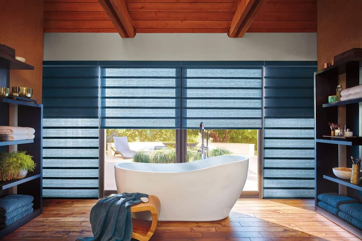 Blue Hunter Douglas Vignette® Roman Shades hanging above a bathtub near Kenner, Lousiana (LA)