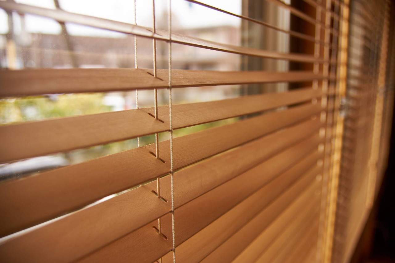 Wooden window blinds hanging on a window near Kenner, LA.
